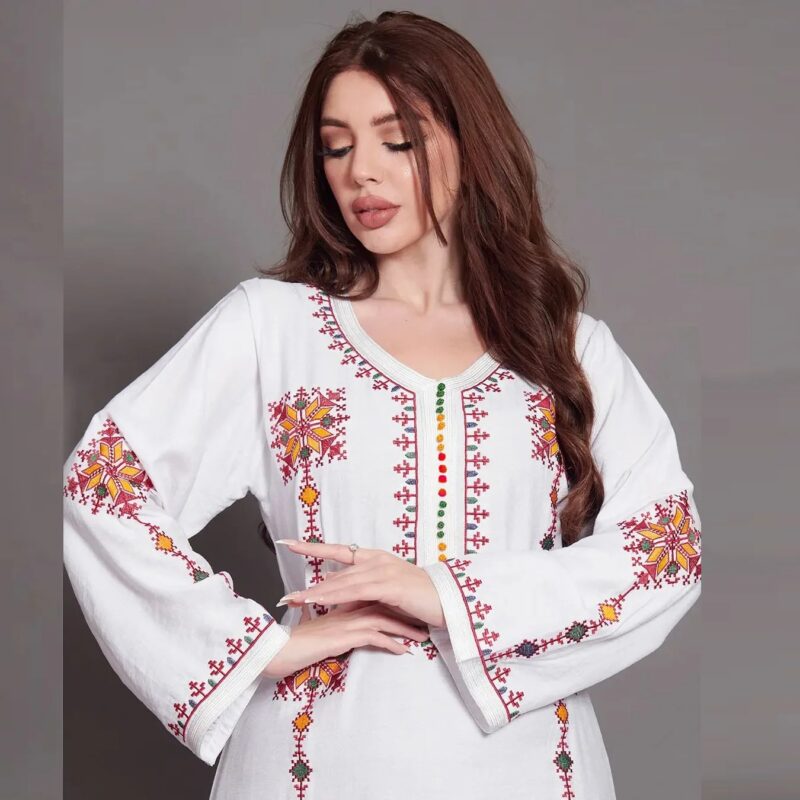 Femme en robe blanche traditionnelle kabyle, détail sur le haut brodé et les manches